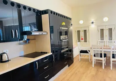 a kitchen with black cabinets and a dining room at Warm Studio MB1 at Marina El Gouna in Hurghada