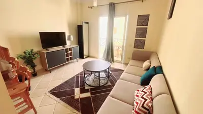 a living room with a couch and a tv at Palm Beach Piazza Beachfront lovely Apartment in Hurghada