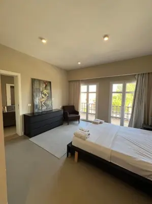 a large bedroom with a large bed and a chair at Modern Apartment Abutig Marina in Hurghada