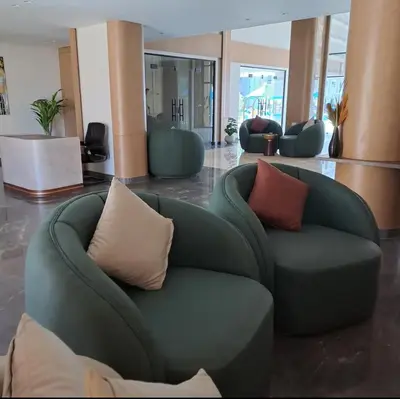a green couch with pillows in a lobby at Tiba gollden resort in Hurghada