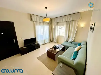a living room with a blue couch and a tv at one bedroom chalet,with sea view terrace in Hurghada