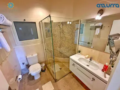 a bathroom with a shower and a toilet and a sink at one bedroom chalet,with sea view terrace in Hurghada