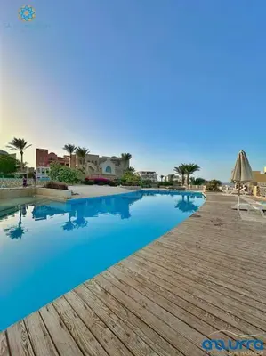 a swimming pool in a resort with blue water at one bedroom chalet,with sea view terrace in Hurghada