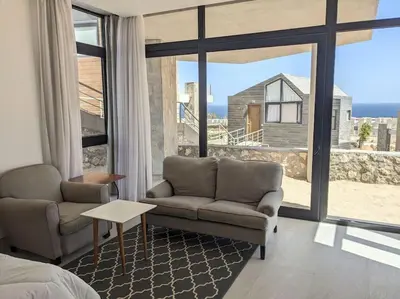 a living room with a couch and a table and windows at Sea View Studio in Soma Bay With Free Beach & Pool in Hurghada