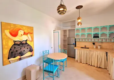 a kitchen with a table and a painting on the wall at Lovely1 Bedroom Downtown ELGouna F04 in Hurghada