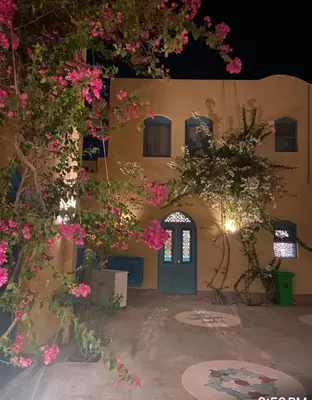 a building with a blue door and pink flowers at Lovely1 Bedroom Downtown ELGouna F04 in Hurghada