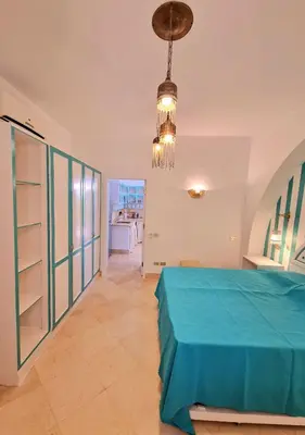 a bedroom with a blue bed and a chandelier at Lovely1 Bedroom Downtown ELGouna F04 in Hurghada