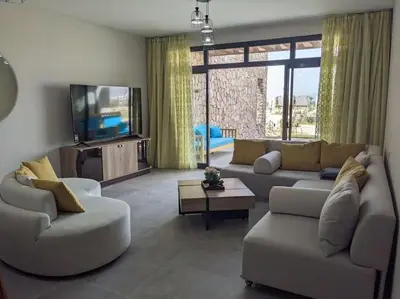 a living room with a couch and a tv at 2BR Somabay Twin Villa in Mesca Near Beach & Pools in Hurghada