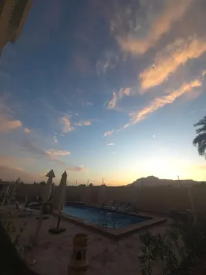 a view of a swimming pool with a sunset at siriuspalaceluxor in Al Karnak