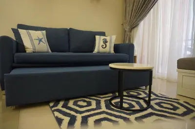 a blue couch in a living room with a table at Casablanca Beach - Panoramic Sea view Apartment in Hurghada