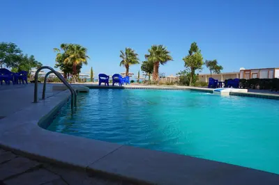 a swimming pool with blue chairs in a resort at Casablanca Beach - Panoramic Sea view Apartment in Hurghada