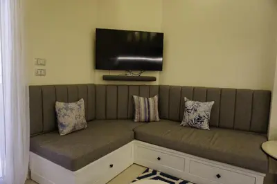 a couch with pillows and a flat screen tv at Casablanca Beach - Panoramic Sea view Apartment in Hurghada