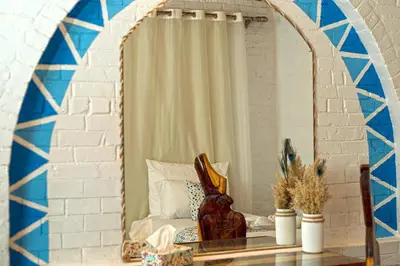 a room with a mirror and a table with a chair at Dolty Kato Nubian House By Kato Dool in Aswan