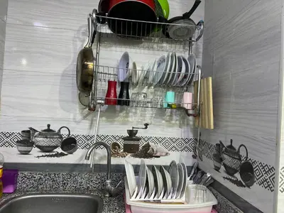 a kitchen sink with plates and utensils on a shelf at Dream apartment1 in Hurghada