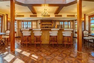 a kitchen with a bar with white stools at Princess Farida Luxury Dahabiya Nile Cruise, Every Monday from Luxor to Aswan 4 nights and Every Friday from Aswan to Luxor 3 nights in Luxor