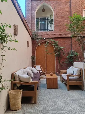 a patio with couches and pillows in front of a building at Kemet House in Luxor