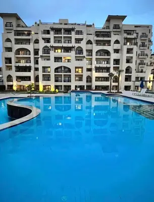 a large swimming pool in front of a building at Aldau Heights Apartment in Hurghada
