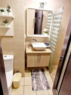 a bathroom with a sink and a toilet and a mirror at Aldau Heights Apartment in Hurghada