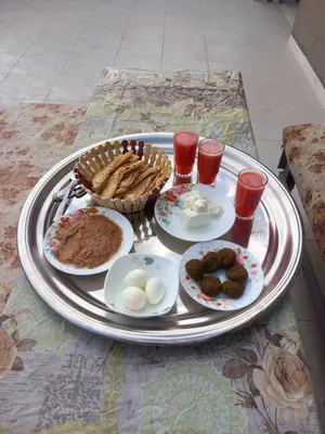 a tray of food with eggs and bread on a table at Rawan apartments in Luxor