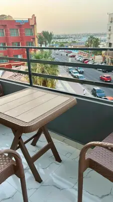a wooden table on a balcony with a view of a city at La Prestigia in Hurghada