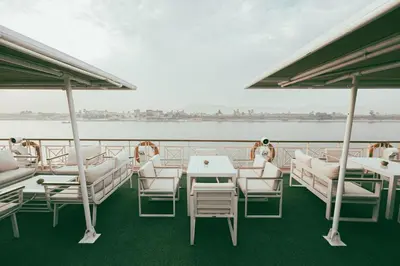 a boat deck with tables and chairs on the water at Orient Grand Rose Nile Cruise - Every Saturday from Luxor for 07 & 04 Nights - Every Wednesday From Aswan for 03 Nights in Luxor