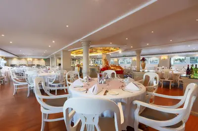 a restaurant with white tables and white chairs at Orient Grand Rose Nile Cruise - Every Saturday from Luxor for 07 & 04 Nights - Every Wednesday From Aswan for 03 Nights in Luxor