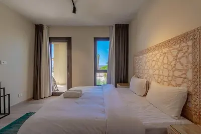 a bedroom with a large bed and a large window at Tranquil 2BR in Shedwan I El Gouna I Pool and Lagoon View in Hurghada