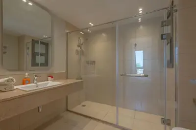 a bathroom with a glass shower and a sink at Tranquil 2BR in Shedwan I El Gouna I Pool and Lagoon View in Hurghada