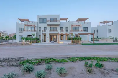 a large white building with a courtyard in front of it at Tranquil 2BR in Shedwan I El Gouna I Pool and Lagoon View in Hurghada