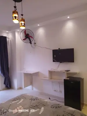 a room with a bed and a tv on the wall at الغردقة كومباوند فلورانزا خمسين in Hurghada