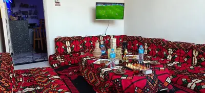 a living room with a red couch with a table at MRHostel Luxor in Luxor