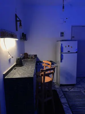 a blue kitchen with a counter and a refrigerator at MRHostel Luxor in Luxor