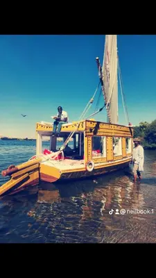 a boat sitting in the water with two people on it at Aswan in Aswan