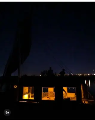 two people standing on a boat at night at Aswan in Aswan