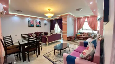 a living room with a couch and a dining room at aswan view 3 bedrooms in Aswan