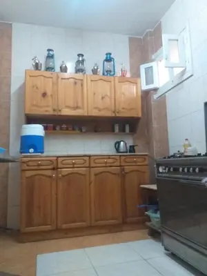 a kitchen with wooden cabinets and a stove at Mourad morsy مراد in Najâ€˜ al MadÄbb