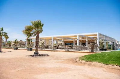a building with a palm tree in front of it at Delightful Gateway in Mangroovy in Hurghada