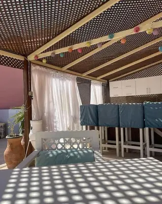 a bedroom with a bed and chairs and a ceiling at Sunny Sea View Studio Marina on private roof in Hurghada