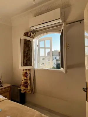 a window in a room with a bed at Sekhmet Appartement sur le roof in Luxor