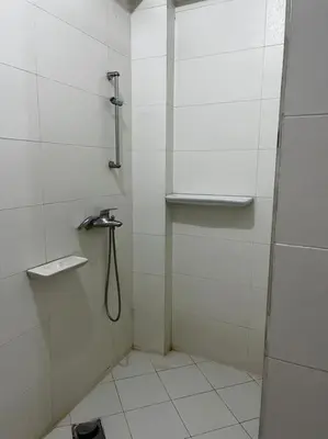 a white bathroom with a shower with a hose at Sekhmet Appartement 2 chambres in Luxor