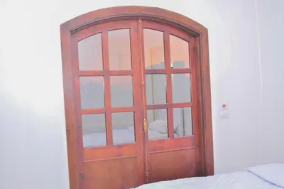 a wooden door in a room next to a bed at king valley House in ‘Ezbet Abu Ḥabashi