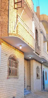 a brick building with a window with a clock on it at king valley House in ‘Ezbet Abu Ḥabashi