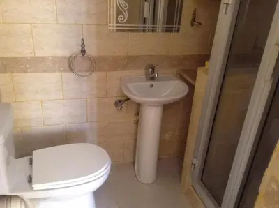 a bathroom with a toilet and a sink at Luxor Stables Apartment in Luxor