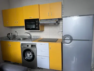 a kitchen with a refrigerator and a washing machine at Sea Light Apartment in Hurghada