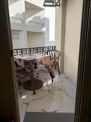 a room with two benches and a table with a cloth at Sea Light Apartment in Hurghada
