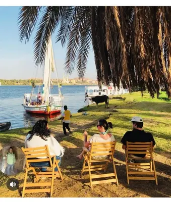 a group of people sitting in chairs on the beach at faloka Farha Camp in Aswan