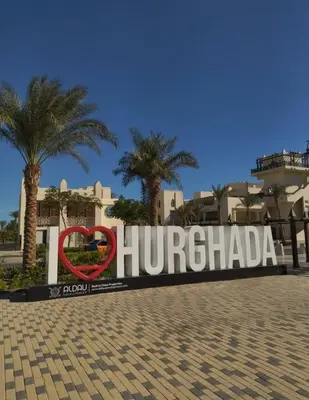 a sign that reads huertaria in front of palm trees at Lux Gardenhouse pool WiFi Private garden Hurghada in Hurghada