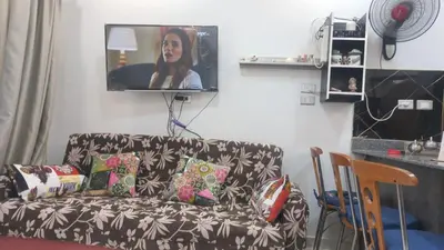 a living room with a couch with a tv on the wall at Juliana Beach Resort in Hurghada