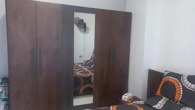 a large wooden cabinet with a mirror next to a bed at Juliana Beach Resort in Hurghada