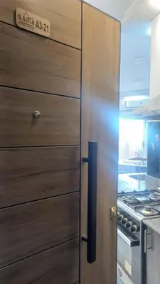 a wooden cabinet in a kitchen with a refrigerator at Juliana Beach Resort in Hurghada